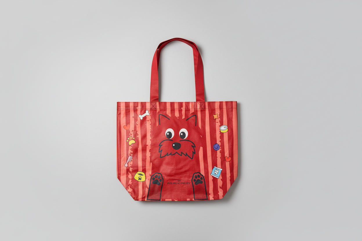 Red striped bag with a cartoon dog face design held by a hand on a light background