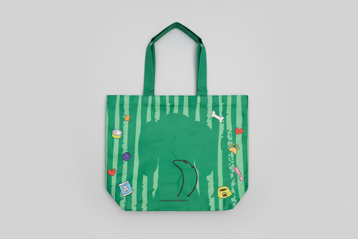 Green striped bag dog with colorful designs held by a hand against a white background
